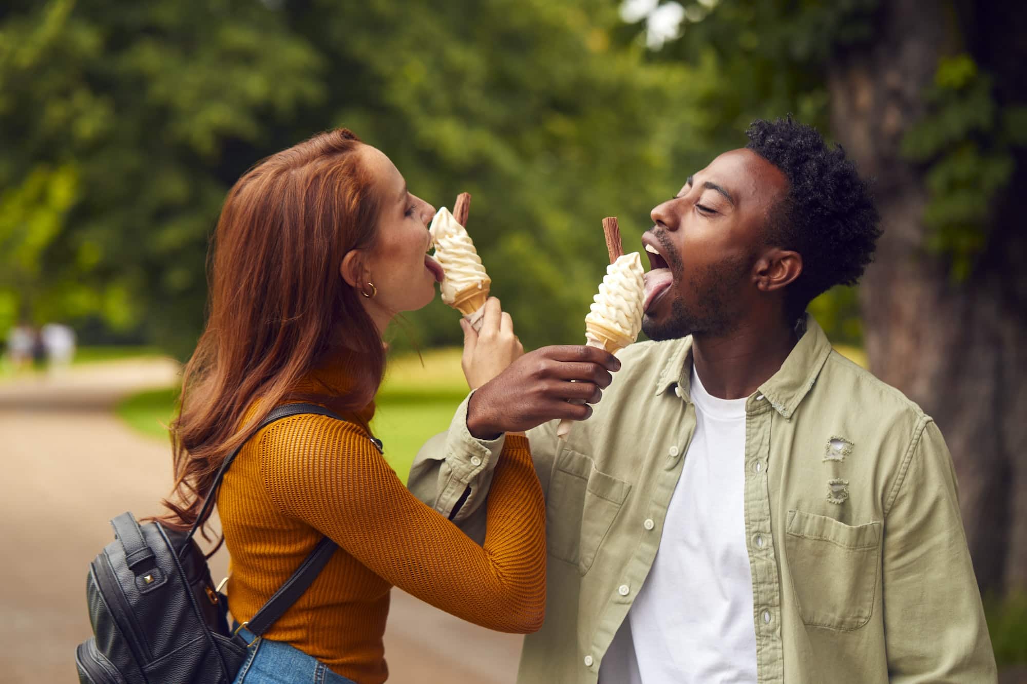 Young Couple Travelling Through City Together Eating Ice Creams In Park